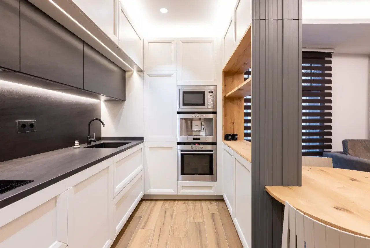 Cocinas peque&ntilde;as modernas con gabinetes blancos y oscuros, electrodom&eacute;sticos integrados y encimeras de cuarzo.