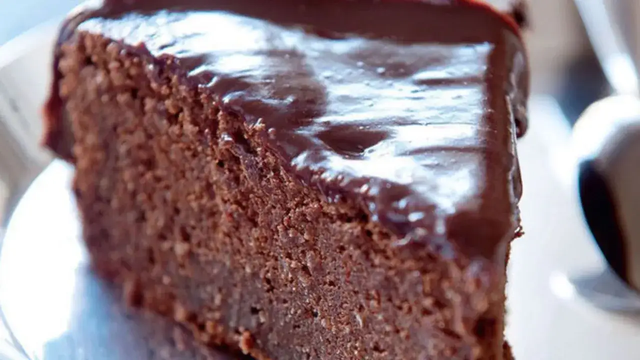 Tranche de g&acirc;teau chocolat sans gluten, riche et moelleux, &agrave; la poudre d'amande, napp&eacute; d'un gla&ccedil;age brillant.