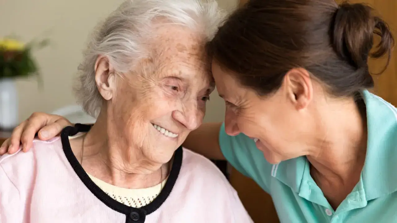 Un abbraccio affettuoso tra due donne, una anziana con capelli bianchi e una più giovane, che affrontano insieme le sfide dell'alzheimer peggioramento improvviso.