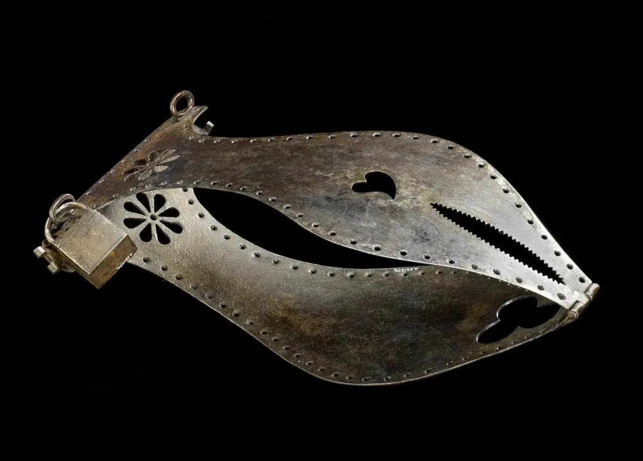 Metalowy pas cnoty, ozdobiony kwiatami i sercem, z ząbkowanym zamknięciem.