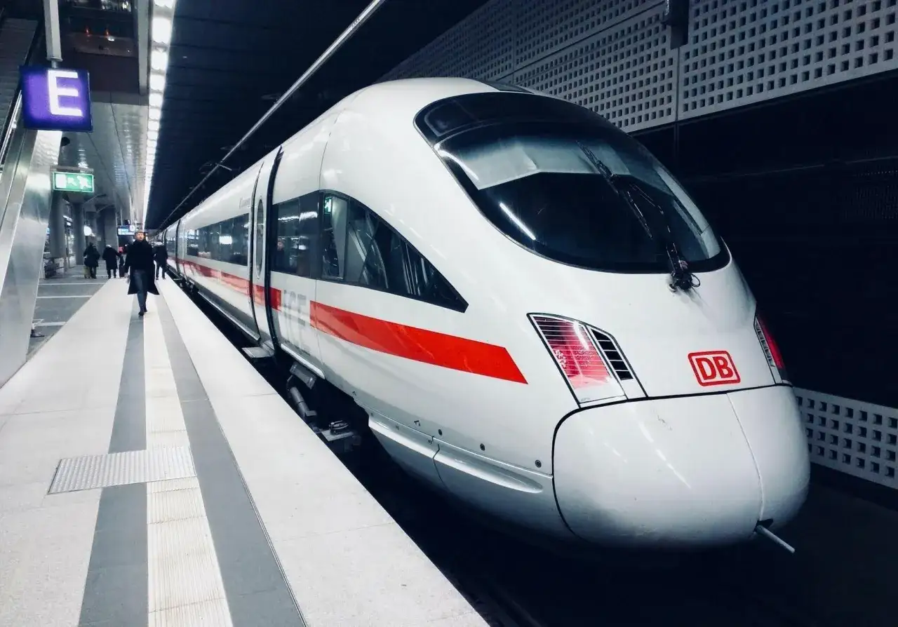 Biały pociąg ICE z czerwonym pasem na peronie, gotowy do podróży do Niemiec.