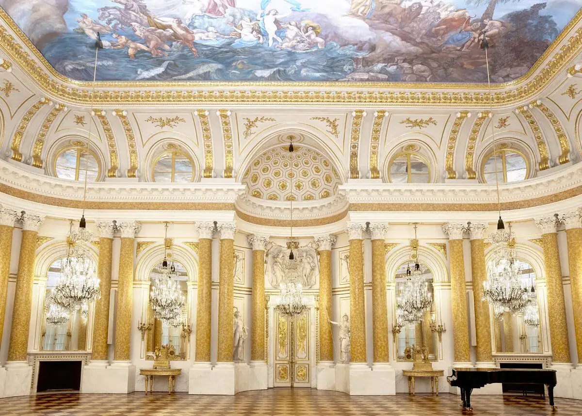 Złota sala balowa z malowidłem na suficie, kryształowymi żyrandolami i fortepianem. Wyobraź sobie, że to część królewskiego traktu w Warszawie.