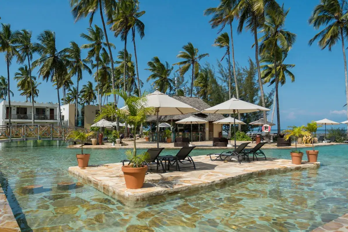 Zanzibar, pora deszczowa. Luksusowy basen z palmami i leżakami, idealne miejsce na relaks po deszczu.