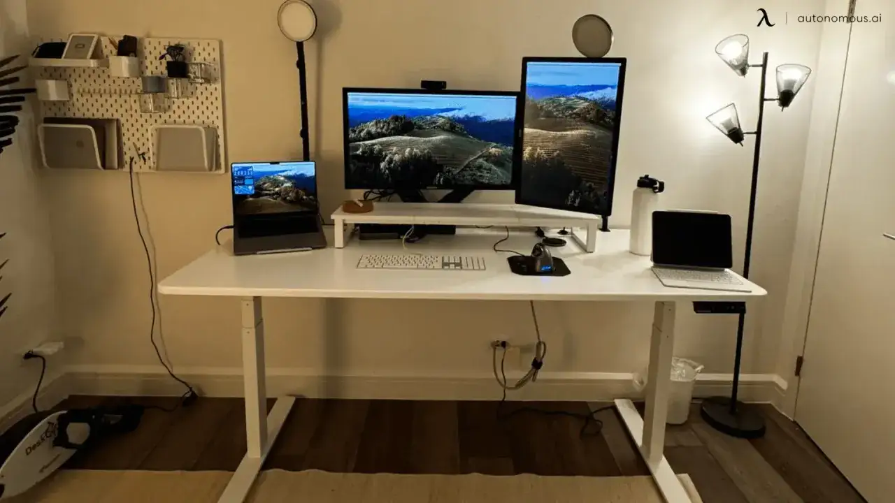 Bureau moderne avec deux &eacute;crans, un ordinateur portable et une tablette. Le choix entre 27 pouces vs 32 pouces pour les moniteurs est crucial pour l'espace de travail.