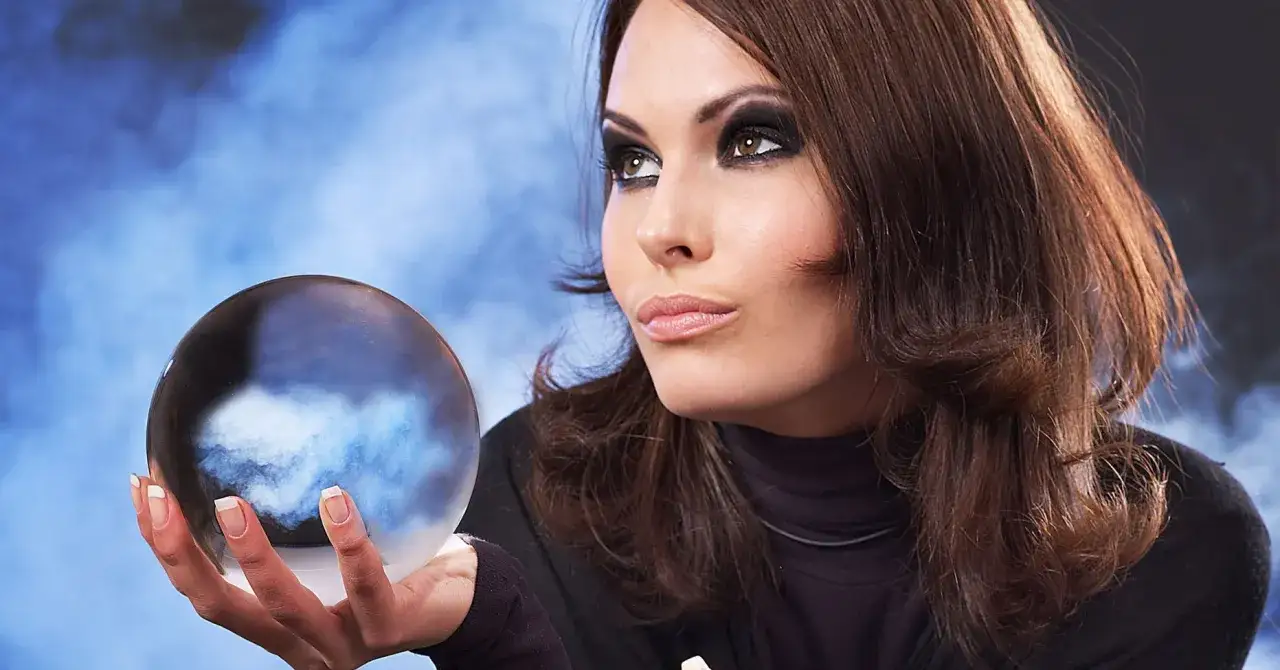 Kobieta z kryształową kulą w dłoni, szukająca szczęśliwych liczb dla lwa w lotto.