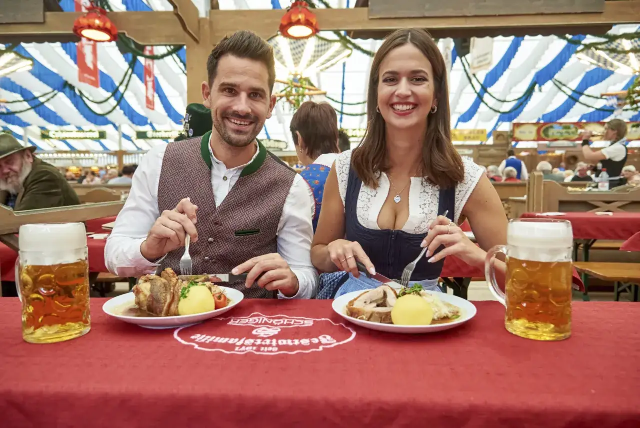 Ein Paar genießt deftiges Essen und Bier auf dem Frühlingsfest München.