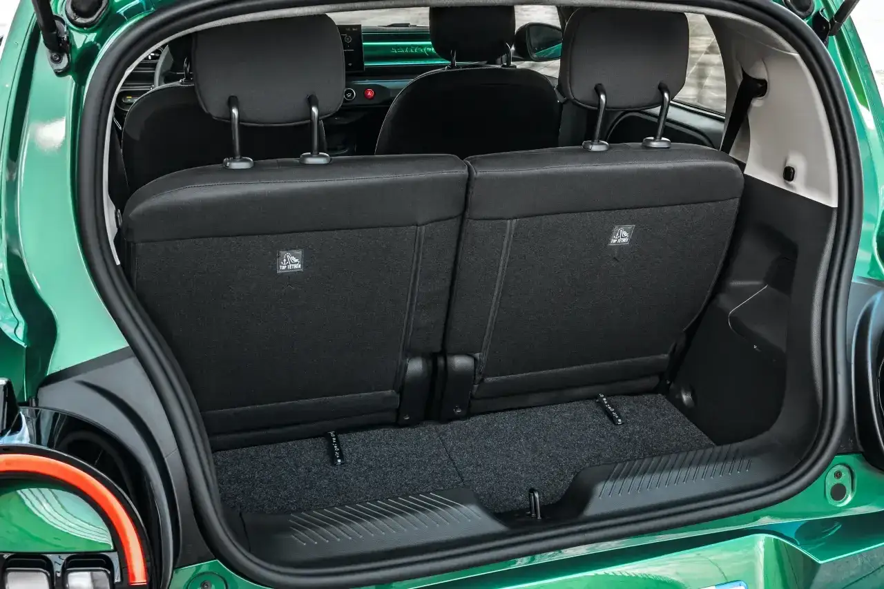 Bagażnik zielonego Renault Twingo Electric z opuszczonymi tylnymi siedzeniami. Widoczne mocowania ISOFIX.