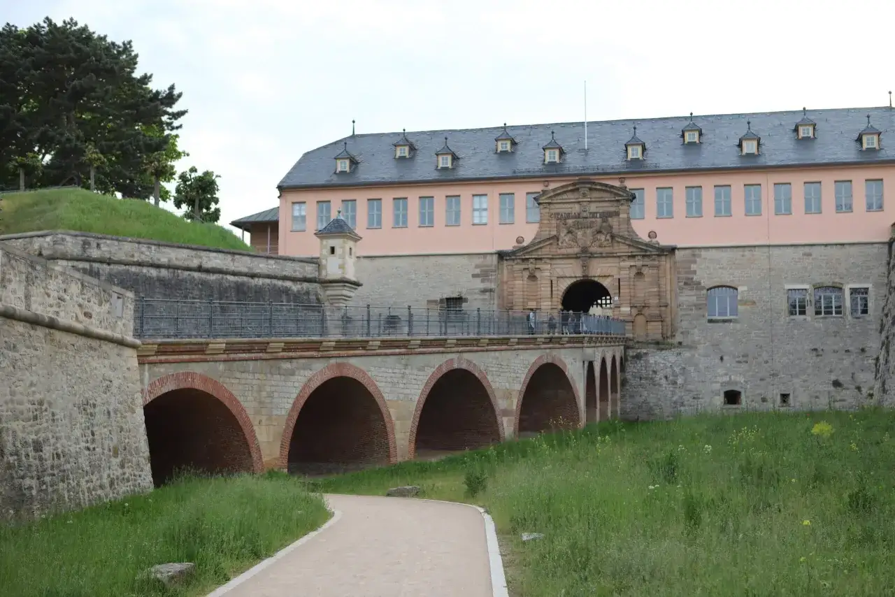Eine Br&uuml;cke f&uuml;hrt zur Zitadelle Petersberg, einem historischen Ort, den man in Erfurt entdecken kann.