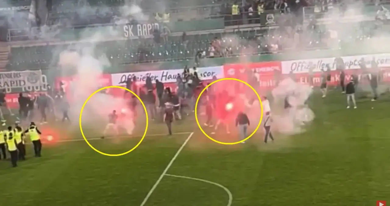 Na boisku Allianz Stadion fani odpalają race, tworząc kłęby dymu.