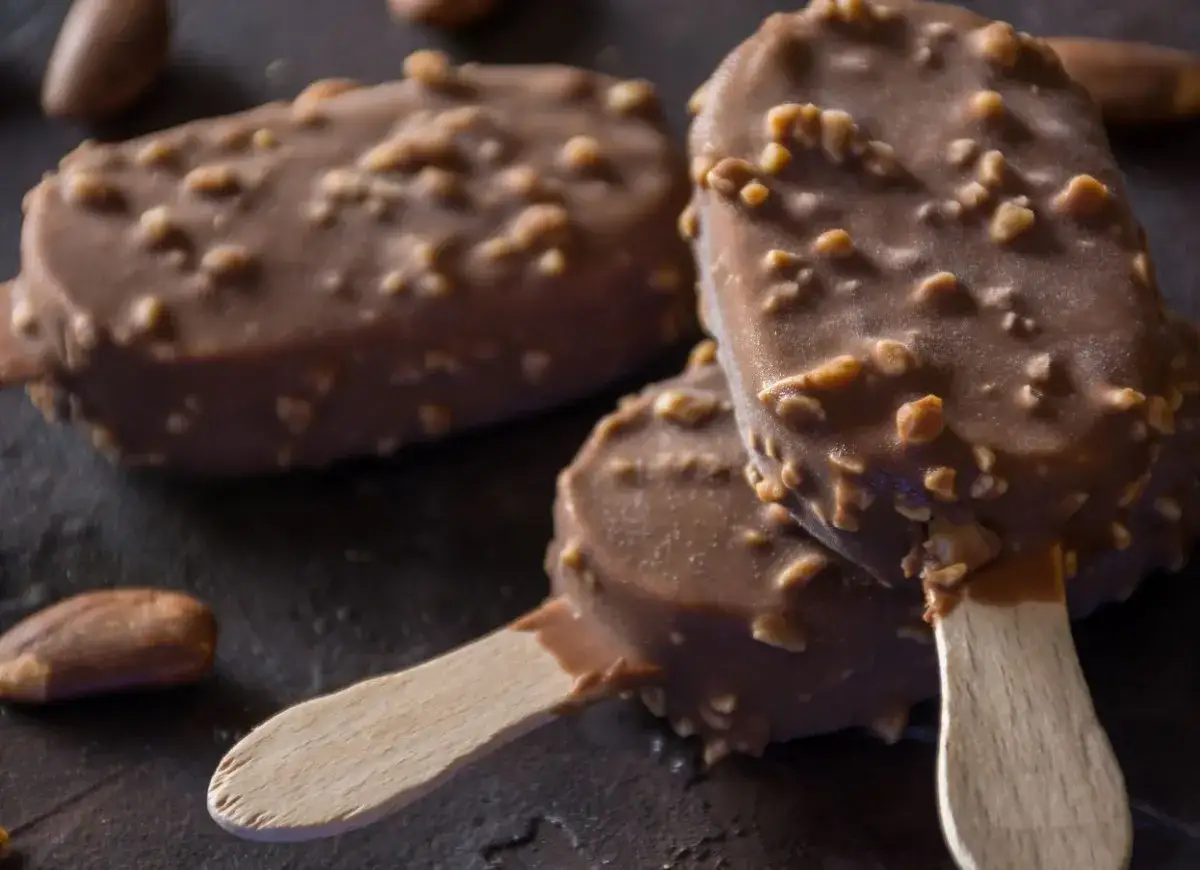 Trzy czekoladowe lody na patyku, pokryte orzechami, przypominają pysznego noggera.