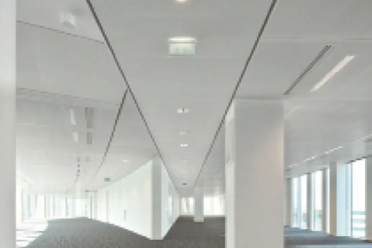 Couloir moderne avec un plafond technique blanc, des lignes &eacute;pur&eacute;es et des luminaires int&eacute;gr&eacute;s.