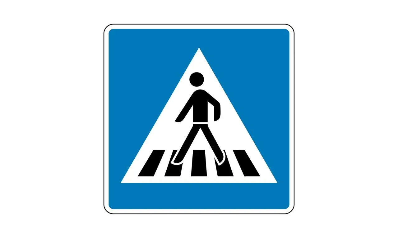 Verkehrszeichen 350: Fu&szlig;g&auml;nger&uuml;berweg. Ein Mann &uuml;berquert die Stra&szlig;e auf einem Zebrastreifen.