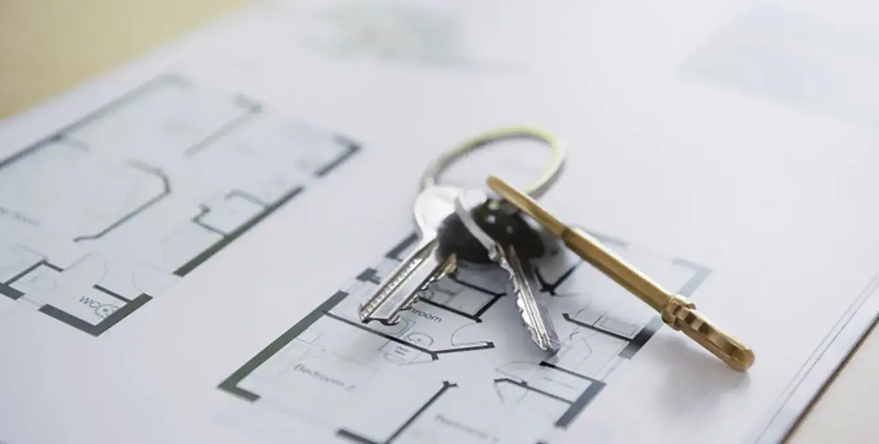 Klucze do nowego domu leżą na planie architektonicznym. Zastanawiasz się, ile się czeka na odbiór domu?