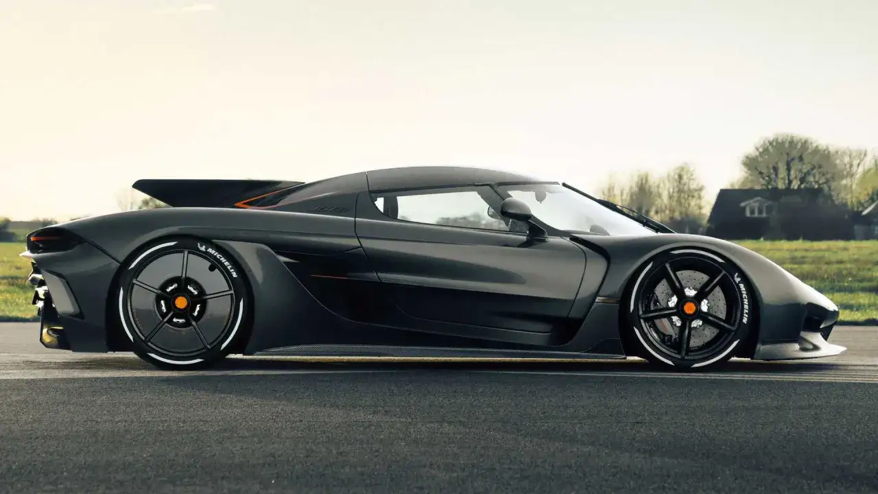Mörkgrå Koenigsegg Jesko Absolut, redo för en acceleration från 0-100 km/h. Dess aerodynamiska linjer och kraftfulla utseende fångar blicken.