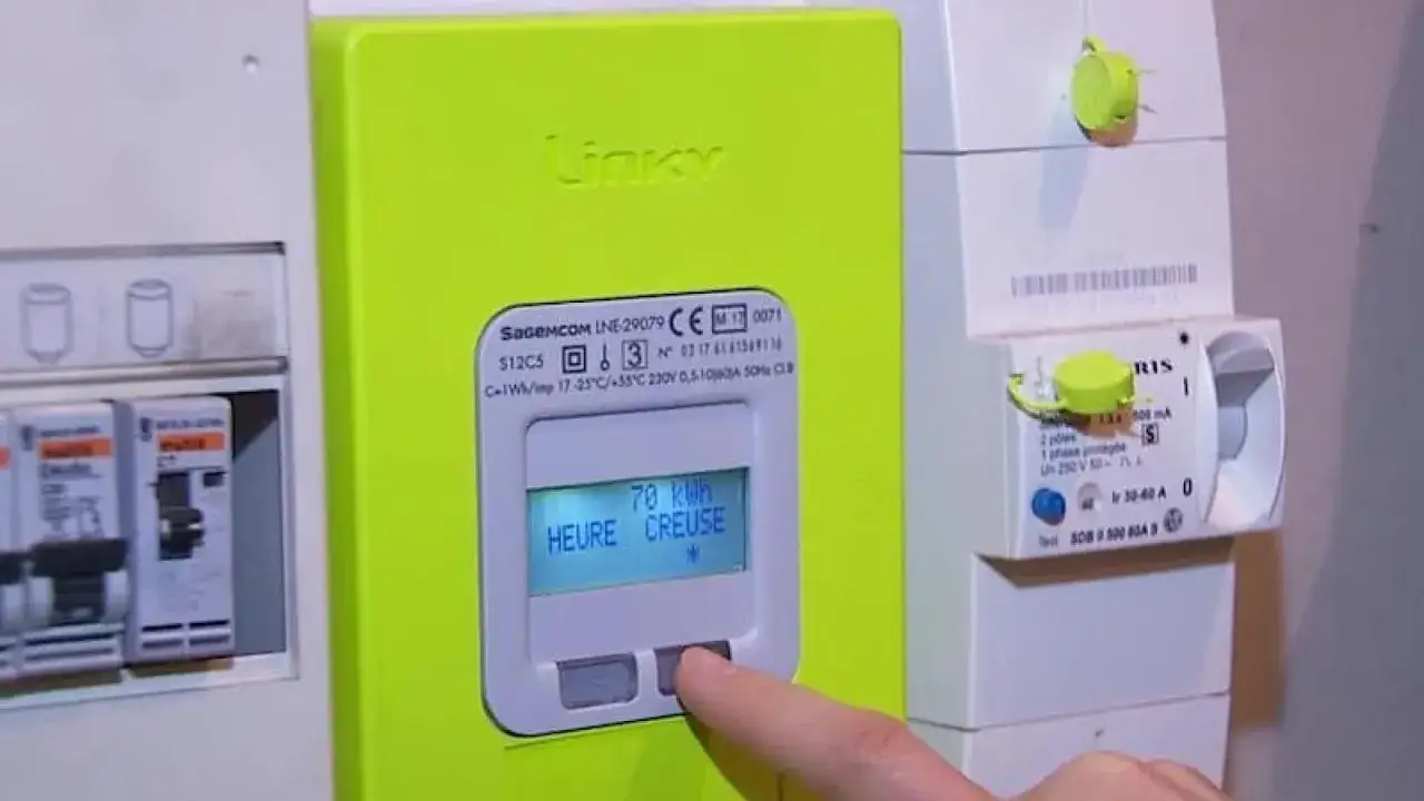 Un doigt appuie sur un compteur Linky affichant 