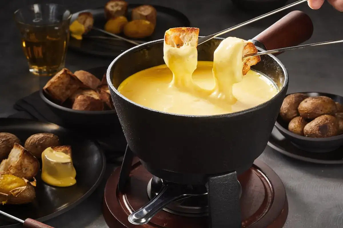 Fonduta, un classico dei piatti tipici Valle d'Aosta, con pane tostato e patate.