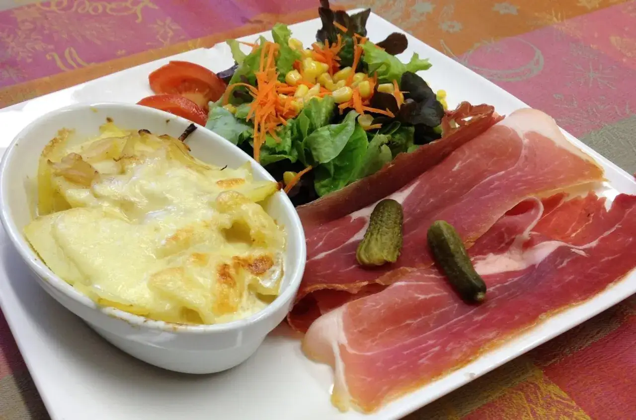 Une assiette gourmande : gratin dauphinois, salade verte et jambon cru, une belle entrée auvergnate.
