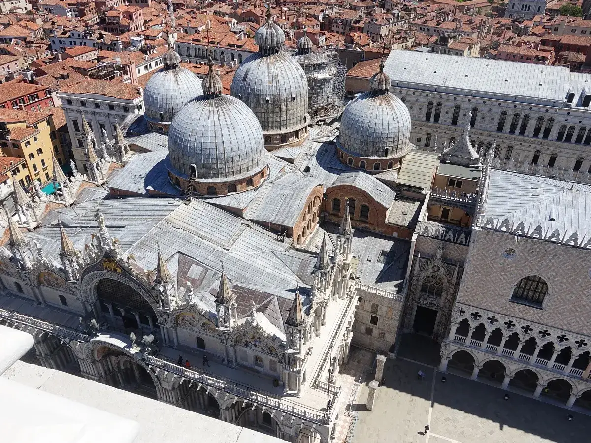 Vista aerea della Basilica di San Marco con le sue cupole argentate e il Palazzo Ducale. La torre di San Marco domina il panorama.