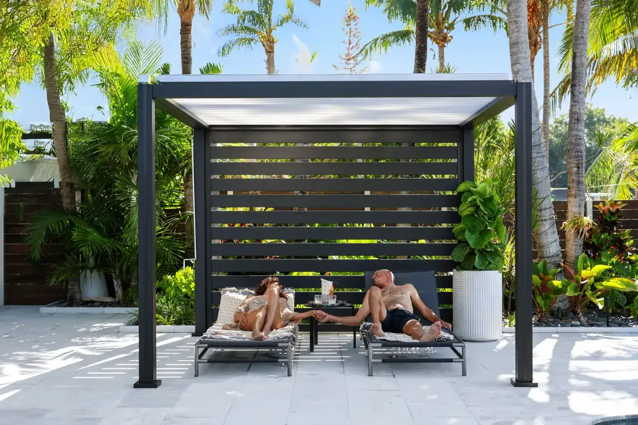 Ein Paar entspannt sich unter einer modernen Pergola, die als Sichtschutz im Garten dient. Tolle Sichtschutz Garten Ideen f&uuml;r Privatsph&auml;re.