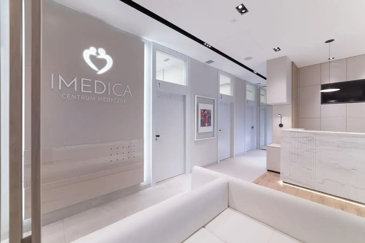 Nowoczesne wnętrze centrum medycznego IMEDICA z recepcją i poczekalnią.