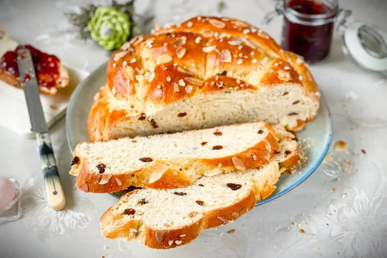 Frisch gebackenes Osterbrot mit Rosinen und Mandeln, bereit zum Genie&szlig;en mit Marmelade.