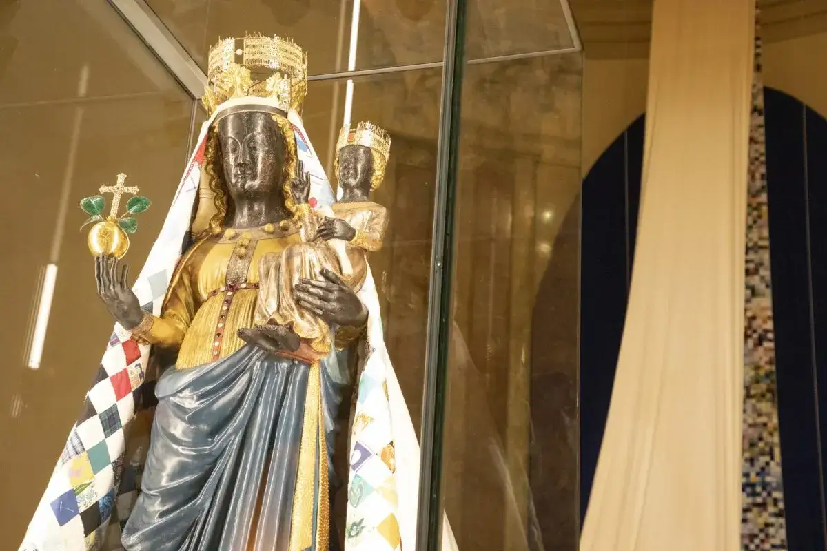 Statua madonna nera con Bambino, incoronati, in un'esposizione. La Madonna tiene un globo con croce.