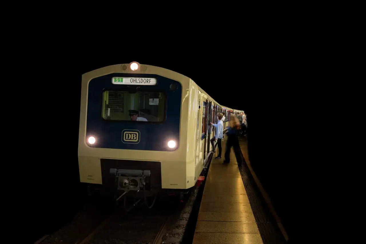 Ein S-Bahn-Zug der DB steht nachts am Bahnsteig. Menschen steigen ein, bereit f&uuml;r die museumsnacht hamburg.