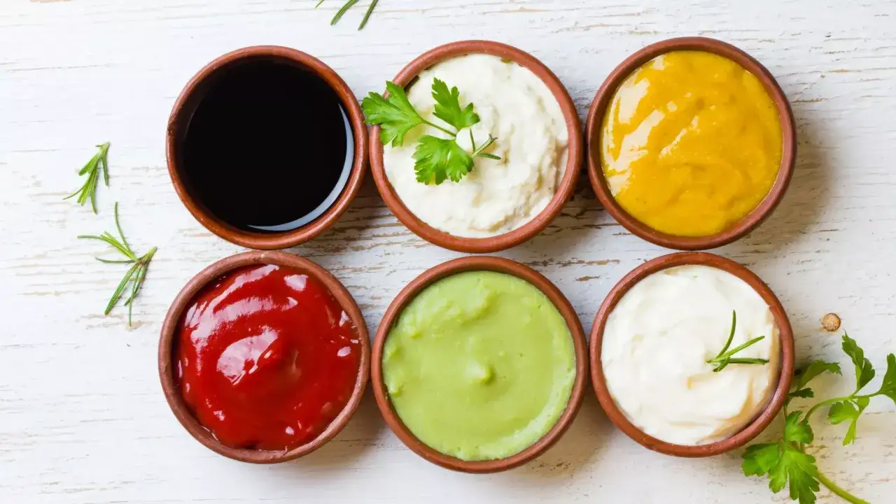 Seis salsas en cuencos de barro: kétchup, mayonesa, mostaza, aguacate, salsa negra y alioli. ¿Cuánto dura el alioli casero en la nevera?
