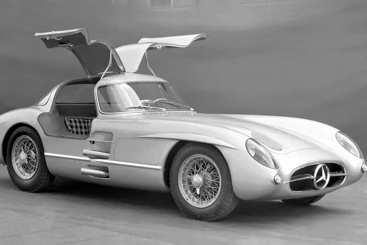 Srebrny Mercedes-Benz 300 SLR Uhlenhaut Coupé, znany jako najdroższe auto na świecie, z otwartymi drzwiami typu gullwing.