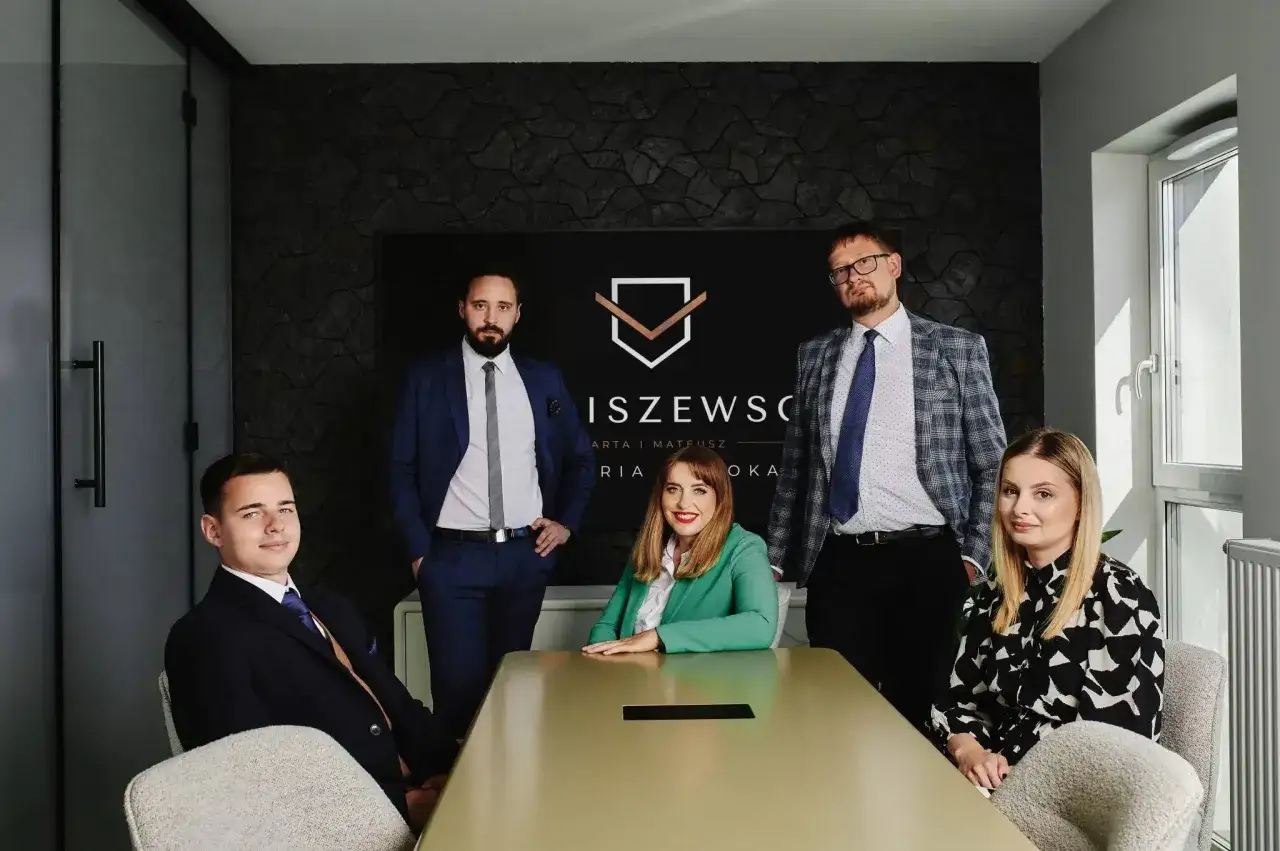 Zespół prawników w nowoczesnym biurze, z logo kancelarii w tle.