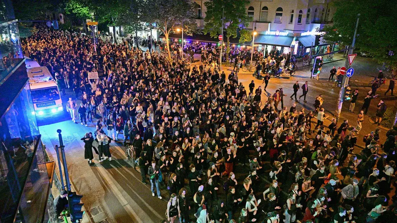 Gro&szlig;e Menschenmenge bei einer Demonstration am 1. Mai in Berlin. Ein Polizeifahrzeug mit Blaulicht steht am Rand.