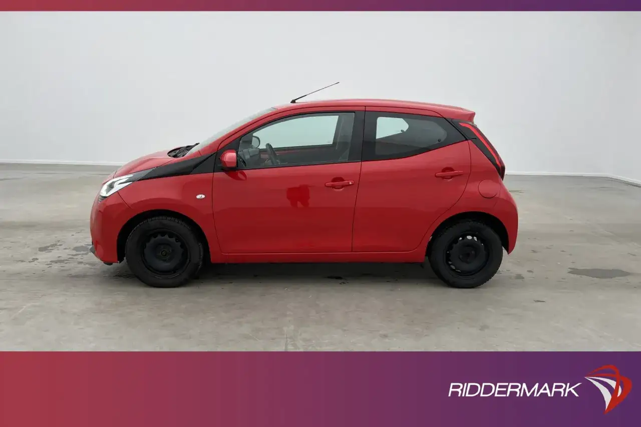 Röd Toyota Aygo, en liten bil som kan ha ett **toyota aygo problem** med sina svarta fälgar.