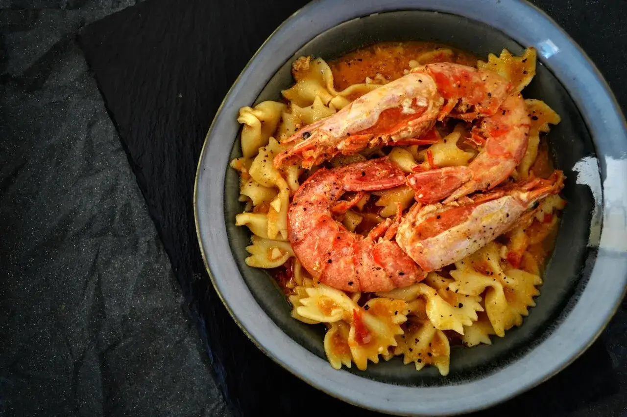 Makaron farfalle z krewetkami w sosie pomidorowym, doprawiony pieprzem, który jest przyprawą uważaną za afrodyzjak.