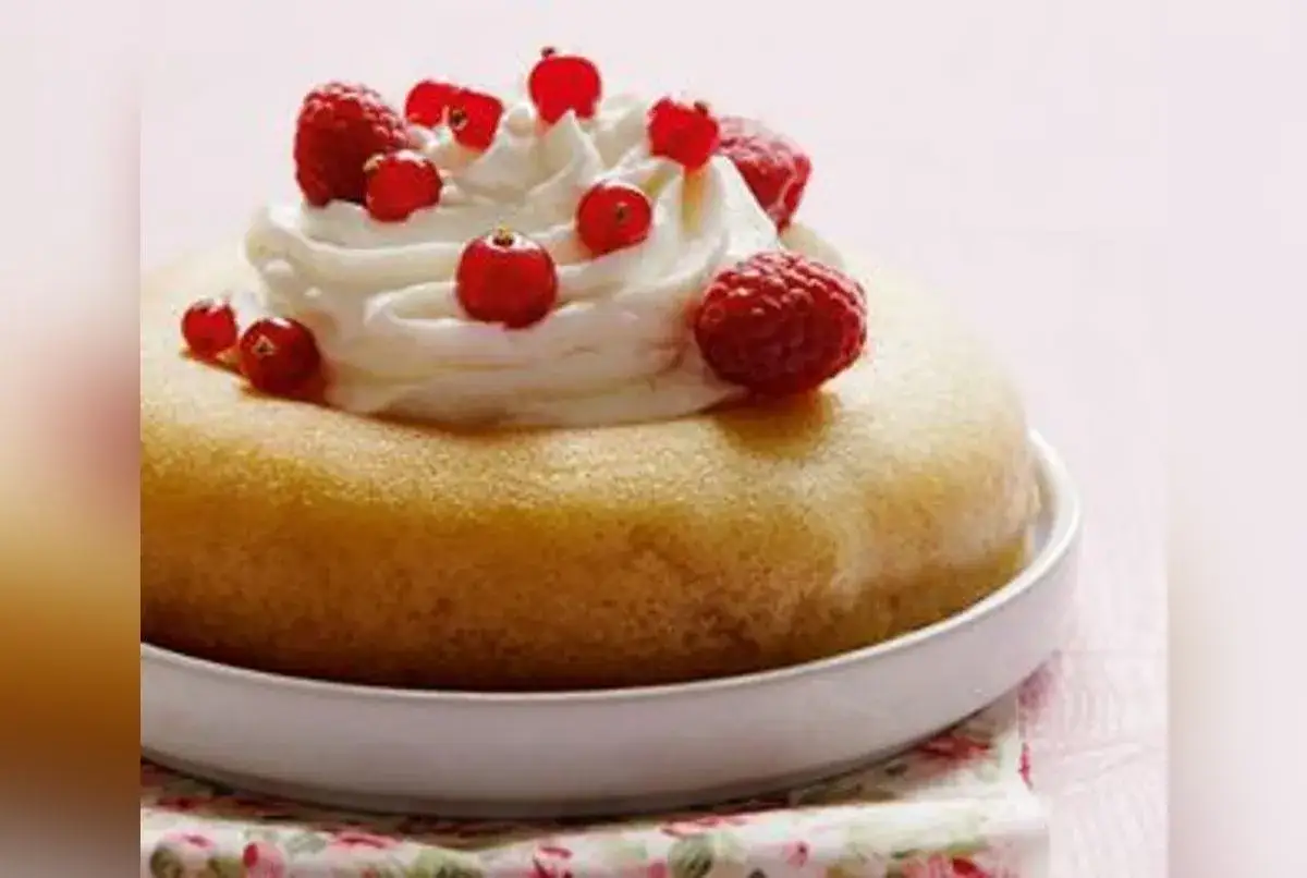 Savarin recette : un gâteau moelleux garni de crème fouettée et de fruits rouges frais, prêt à être dégusté.