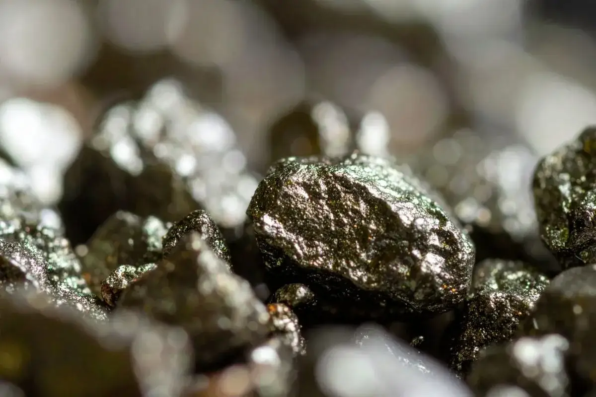 Zbliżenie na błyszczące bryłki pirytu, ukazujące jego metaliczny połysk i nier&oacute;wną teksturę. Piryt właściwości &ndash; kamień ten jest znany ze swojej twardości i odporności.