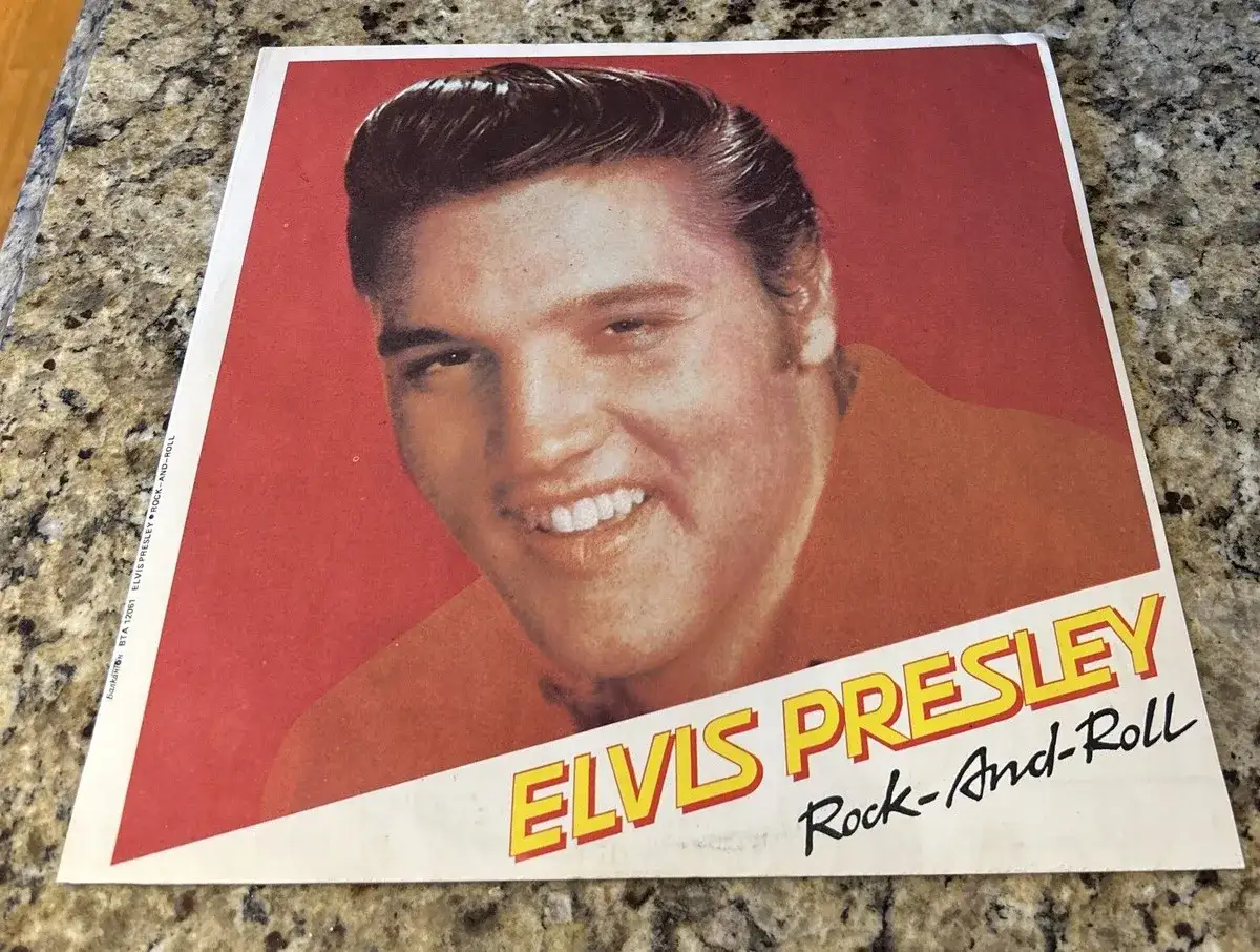 Elvis Presley l&auml;chelt auf dem Cover einer Rock-and-Roll-Schallplatte. Er verk&ouml;rpert, was Musik bedeutet: Leidenschaft und Energie.