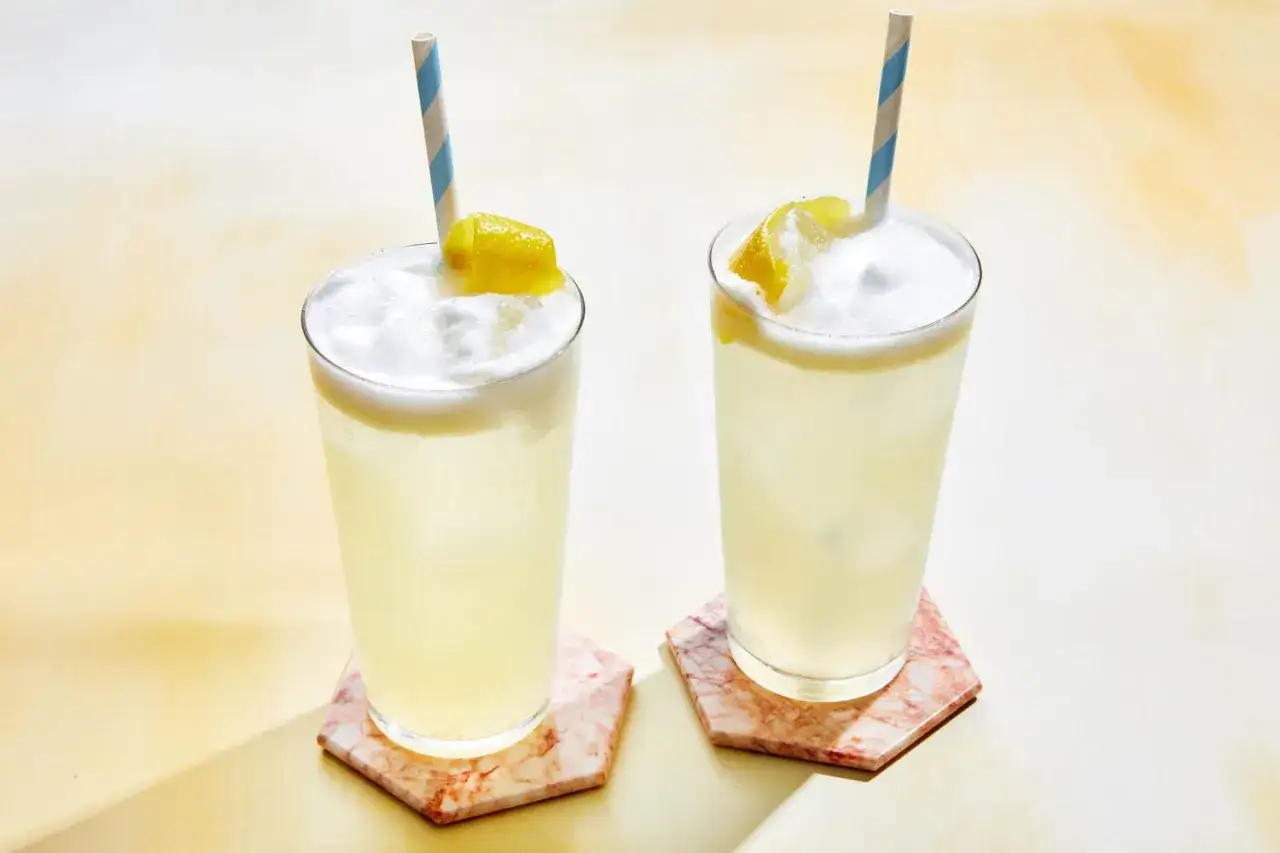 Tv&aring; uppfriskande drinkar, som en Clover Club, med citronskiva och randiga sugr&ouml;r.