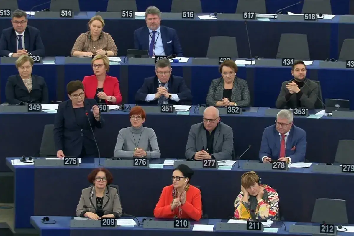 Posłanka przemawia na forum Parlamentu Europejskiego, podczas gdy inni członkowie słuchają.