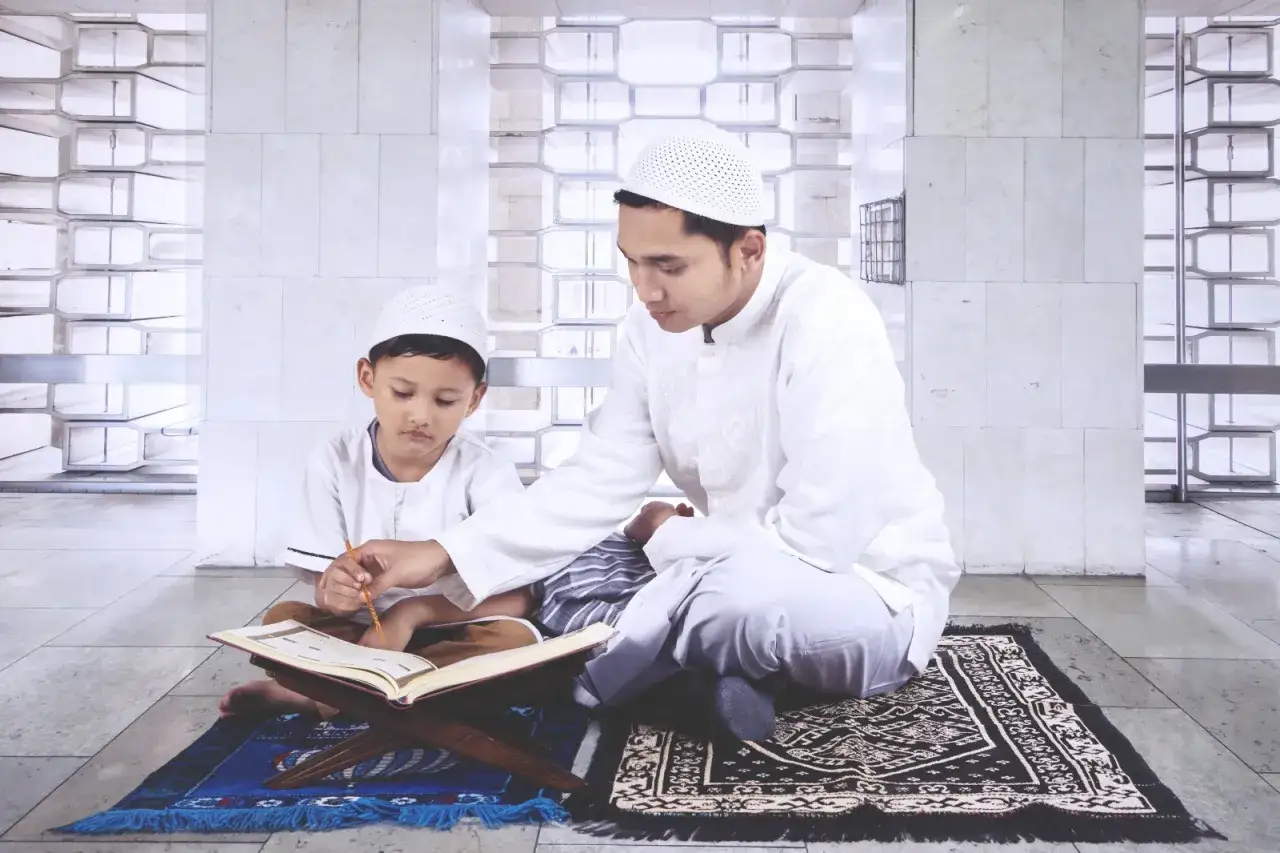 En man visar en pojke hur man blir muslim genom att l&auml;sa ur Koranen.