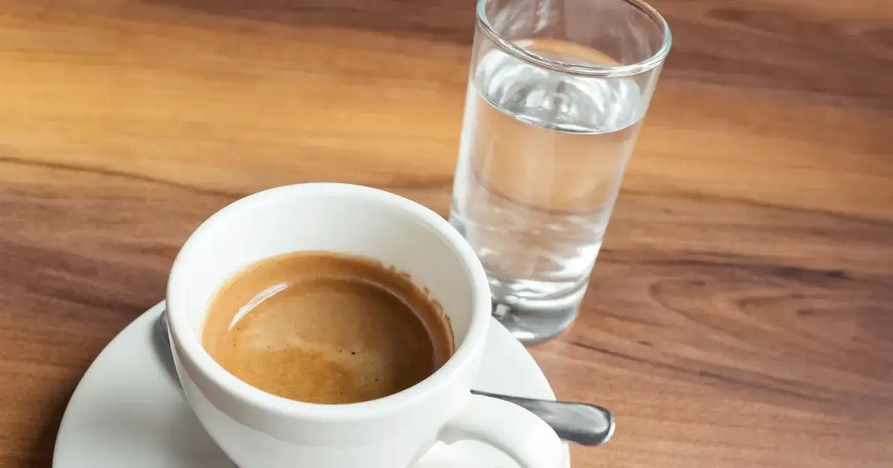 Kawa espresso i szklanka wody na drewnianym blacie. Woda do espresso? To sekret czystego smaku!
