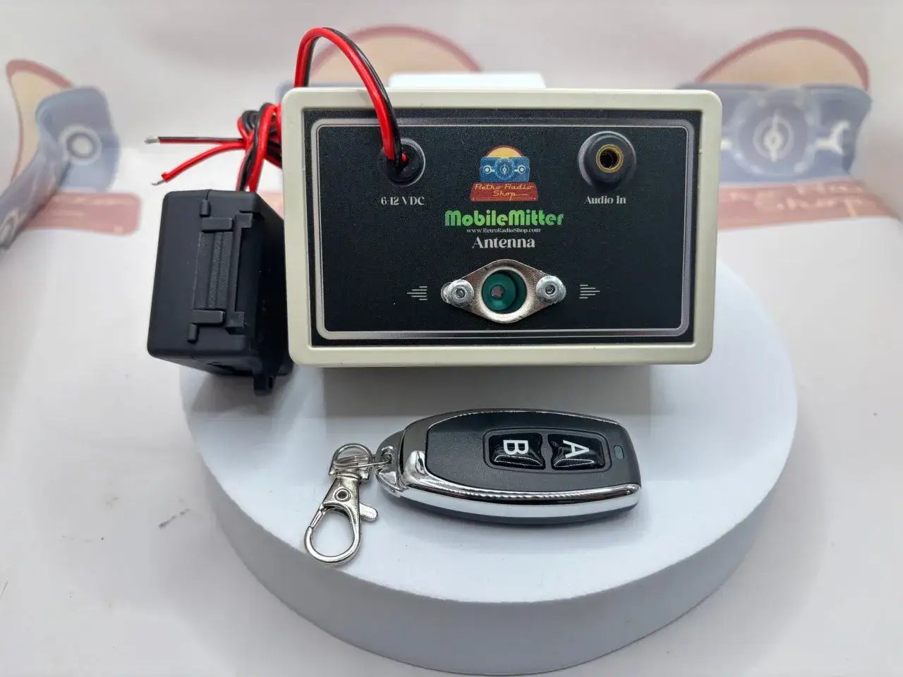 Mit diesem Ger&auml;t l&auml;sst sich ein altes Autoradio mit dem Handy verbinden. Es hat einen Audio-In-Anschluss und wird mit 6-12 VDC betrieben. Ein Schl&uuml;sselanh&auml;nger ist ebenfalls abgebildet.