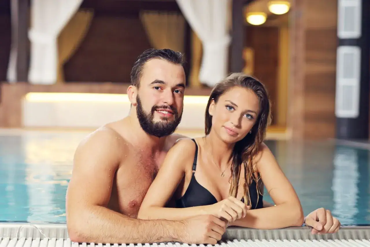 Para, uśmiechnięta para w basenie. Czy to ich pierwsza randka na basenie?