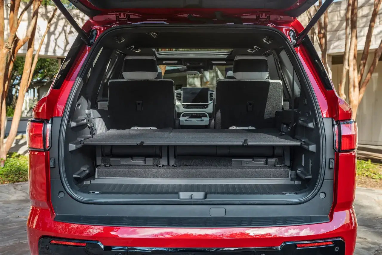 Czerwona Toyota Sequoia z otwartym bagażnikiem, ukazującym przestronne wnętrze z opuszczonymi siedzeniami i schowkami.