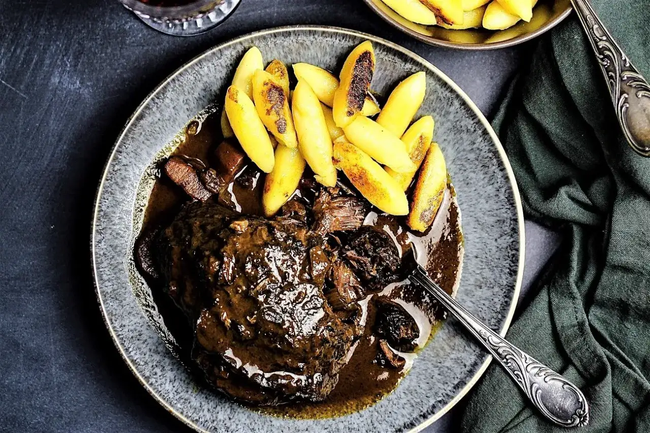 Ein Teller mit zarten Ochsenbacken in dunkler Sauce, serviert mit Klößen. Ein köstliches Ochsenbacken Rezept, das zum Genießen einlädt.