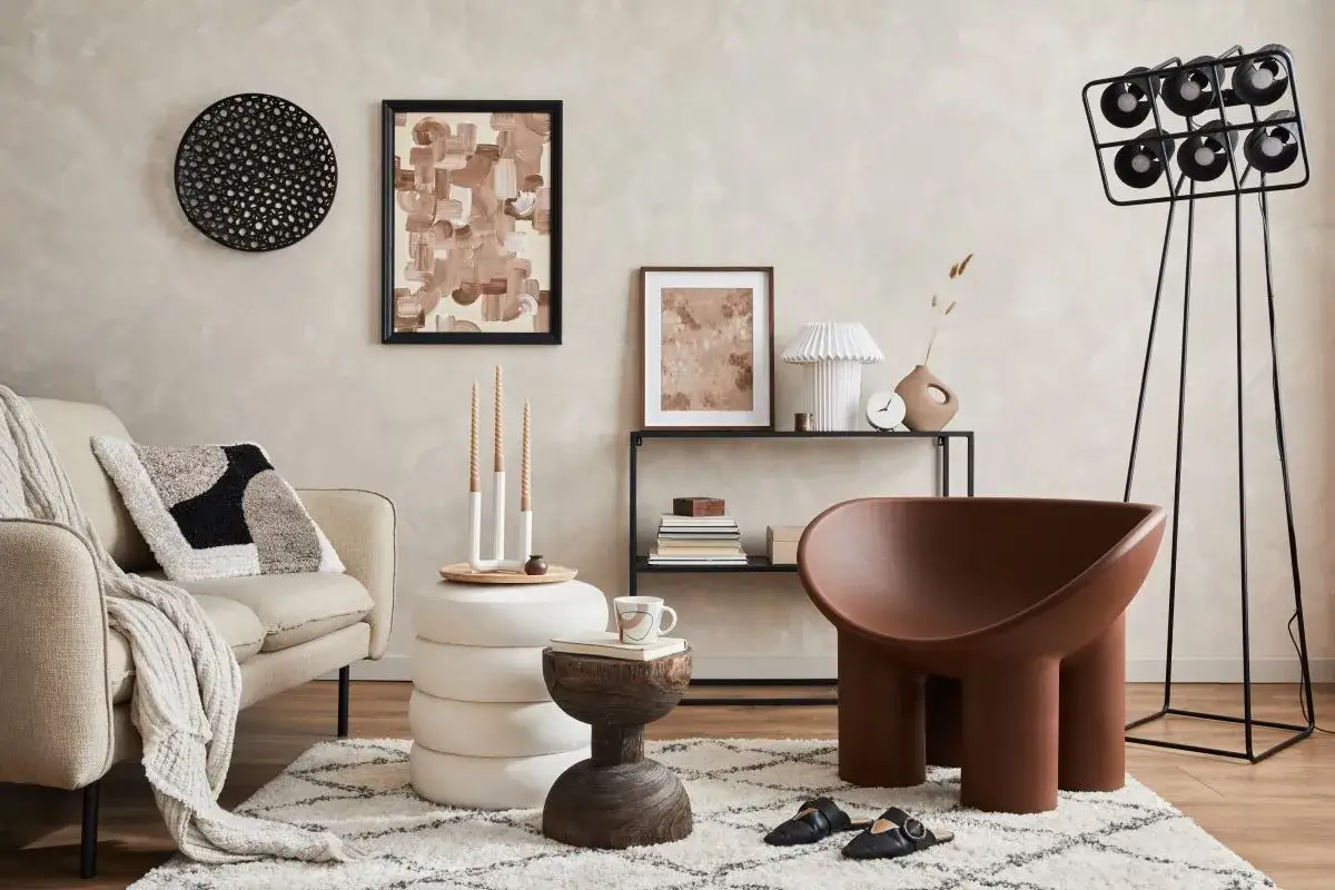 Przytulny salon z sofą pokrytą tkaniną boucle, ozdobiony abstrakcyjnym obrazem i designerskimi meblami.