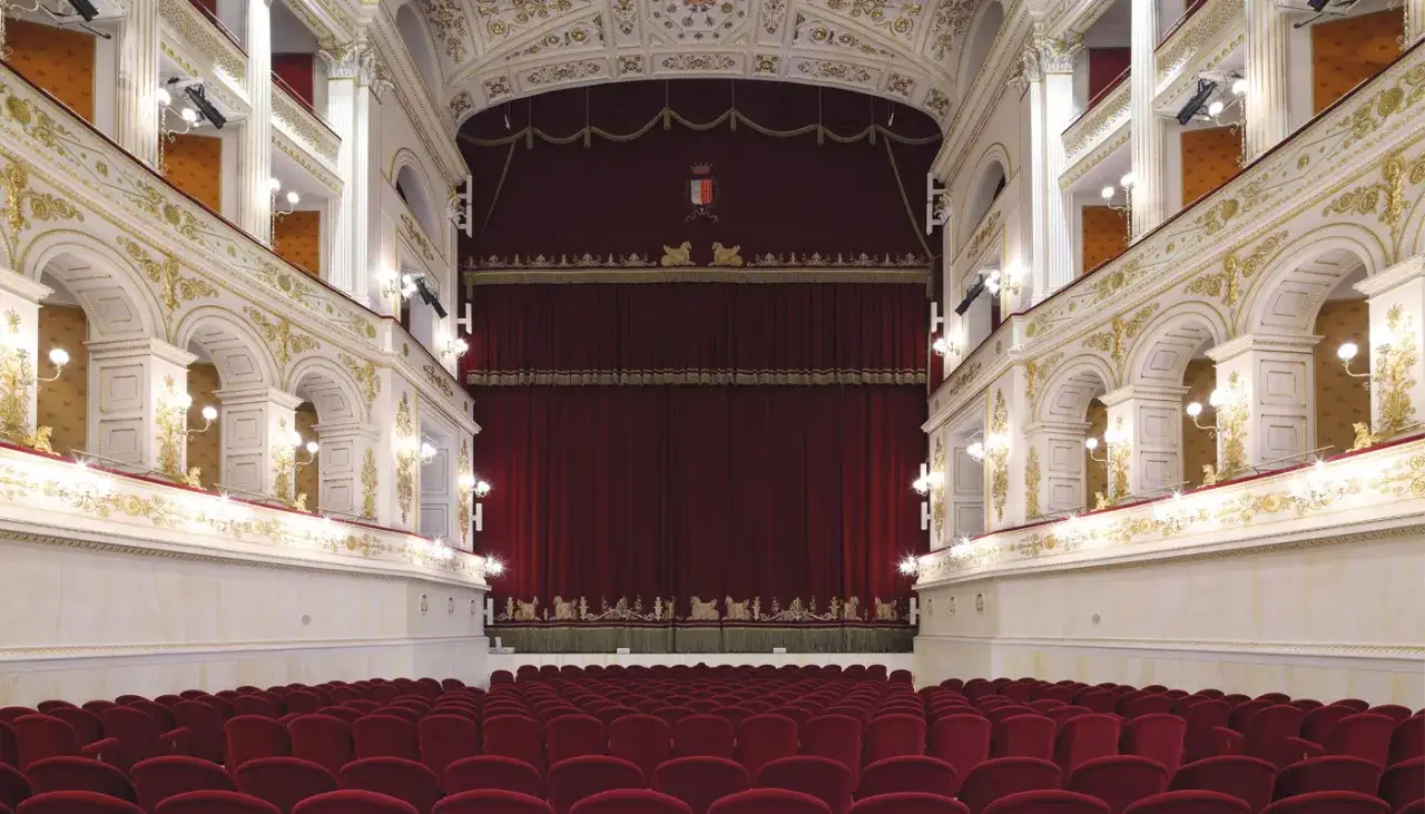 Interno del Teatro Galli di Rimini, con platea di velluto rosso e sontuose decorazioni dorate sui palchi.