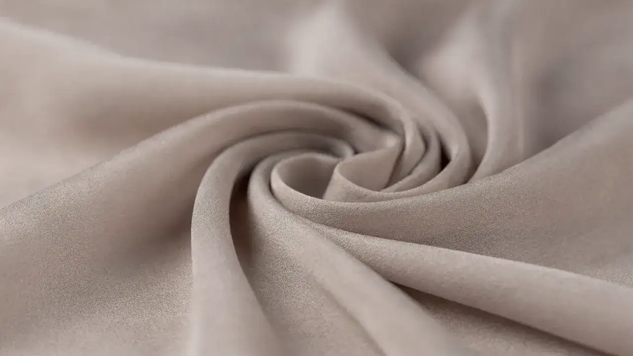 Miękka, beżowa wiskoza układa się w eleganckie fale. To materiał, kt&oacute;ry pięknie się prezentuje i jest przyjemny w dotyku.