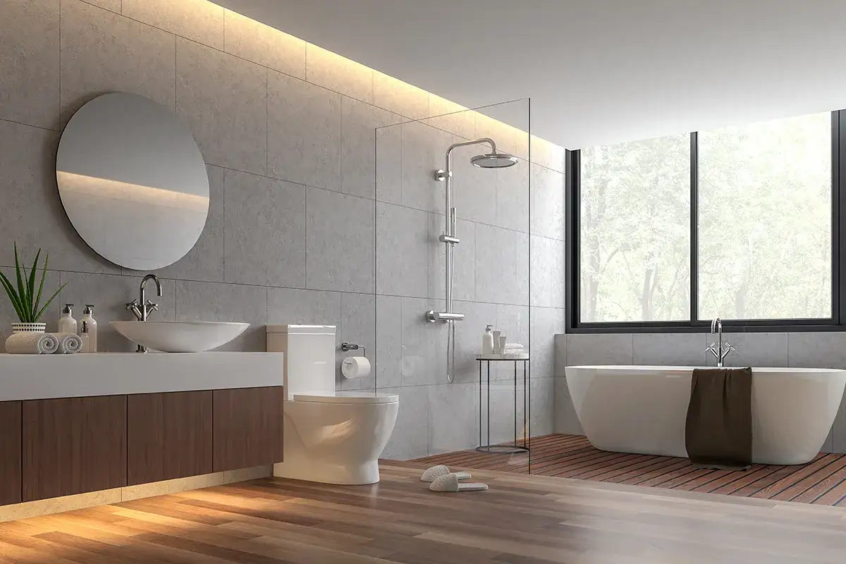 Salle de bain moderne avec baignoire &icirc;lot, douche, lavabo et toilettes. La jonction parquet carrelage cr&eacute;e un contraste chaleureux.