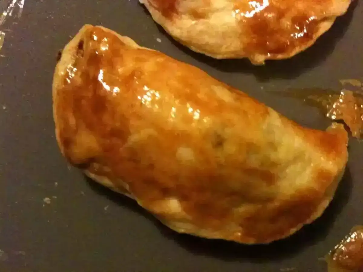 Deux chaussons dorés et brillants, un délice de pastel thon, prêts à être dégustés.