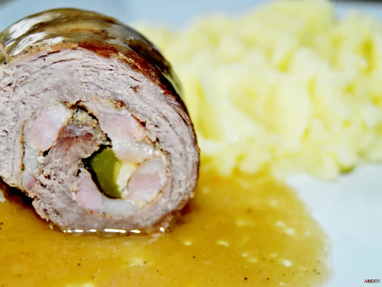 Tradycyjne zrazy wołowe w sosie własnym, z dodatkiem og&oacute;rka kiszonego i boczku, podane z pur&eacute;e ziemniaczanym.